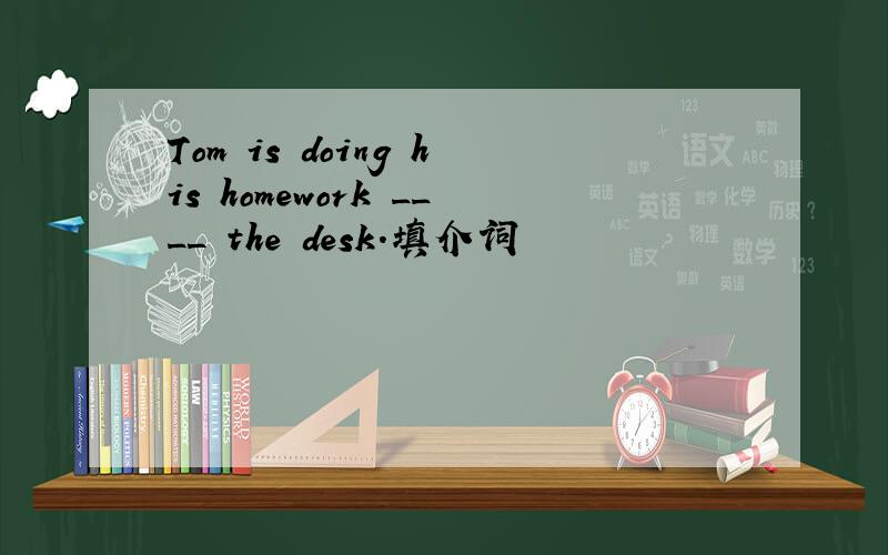 Tom is doing his homework ____ the desk.填介词